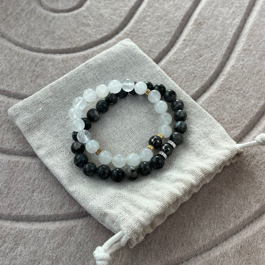 Duo de bracelets Le Fil en pierre de lune et labradorite posé sur son pochon en coton