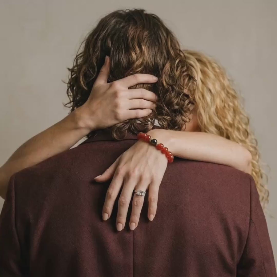 Couple enlacé, bracelet en cornaline au poignet de la femme